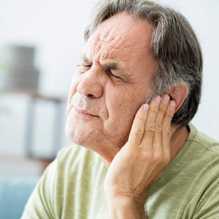 man clutching jaw due to tmj pain